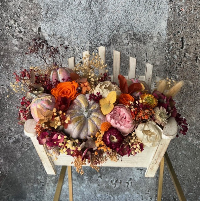 Thanksgiving arrangement with preserved flowers in bench
