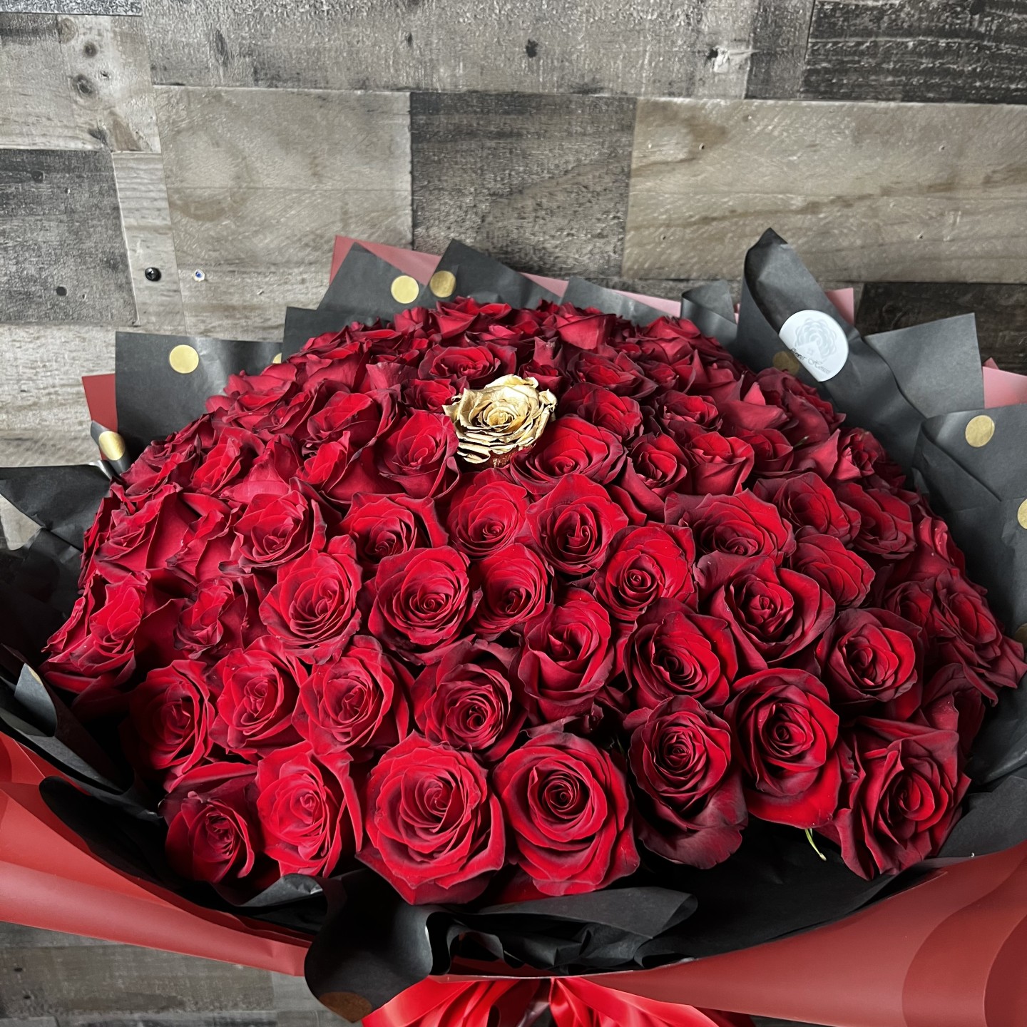 100 Red Roses With 1 Gold Rose In The Middle Hand-Tied Bouquet